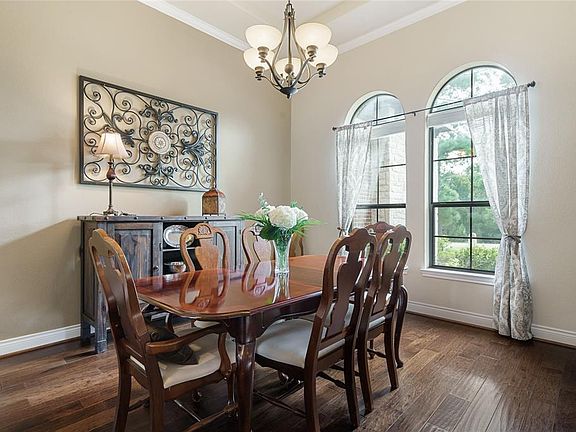 Warm wood floors, crown molding, trey ceiling and large windows in the Formal Dining Room.