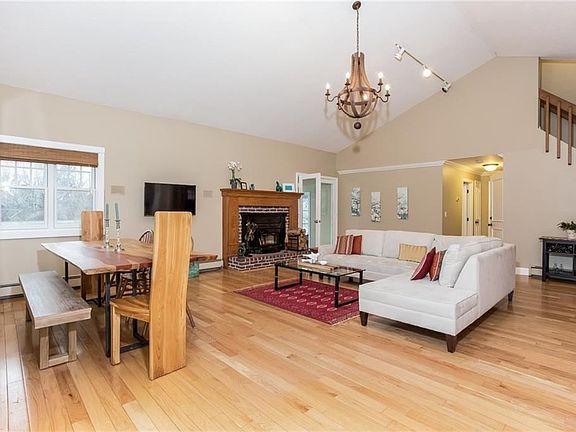 Living room (note vaulted ceiling) with large dining section. Fireplace has enamel insert with blowers. Hall to master bedroom & bath to the right with stairs leading to second floor