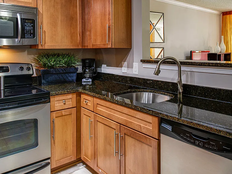Modern kitchen features stainless steel appliances, granite countertops in select homes