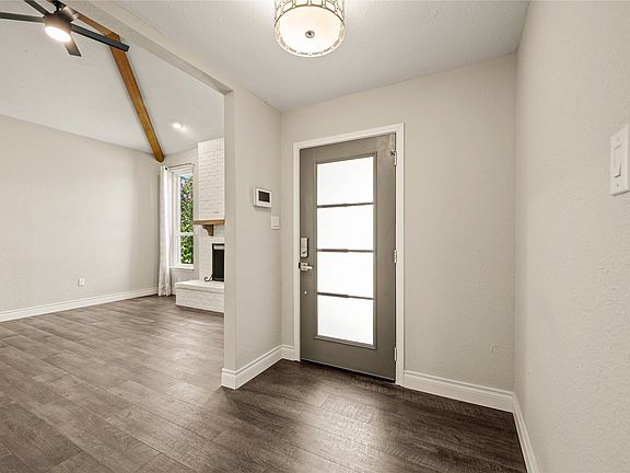 Entry area featuring wood-finish flooring, a modern entry door with frosted glass panels, and a flush mount ceiling light