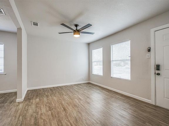 Spare room featuring wood finished floors, a ceiling fan, and healthy amount of natural light