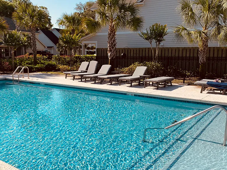 Pool area with seating and palm trees