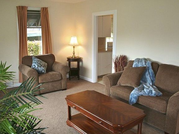The sunny living room features big south facing picture windows, and new paint and carpet.