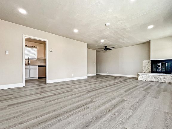 Large living room with recessed lights & decorative fireplace