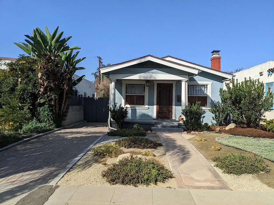 Front of the house with tandem driveway for 2 compact cars.