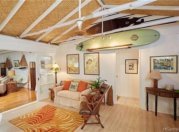 Inviting entry with a cozy spot to hang out and a large book case to the right.