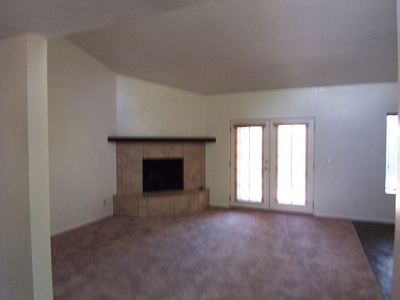 The elegant fireplace and French doors add to the warm ambia