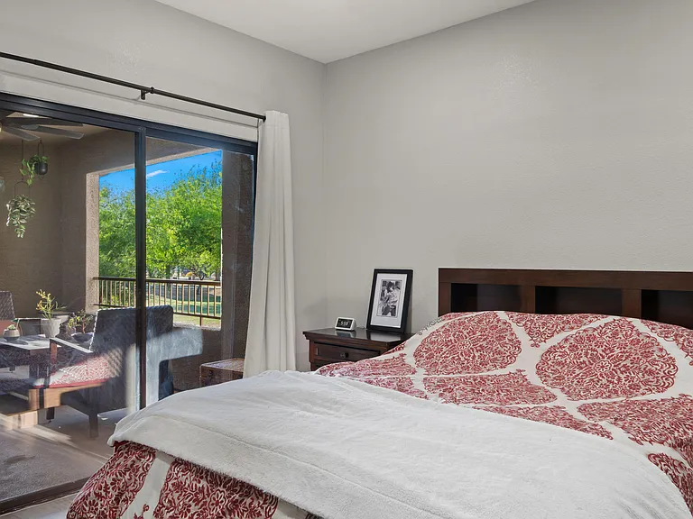 Bedroom with a large sliding glass door to a private balcony, plus space for a nightstand and dresser.