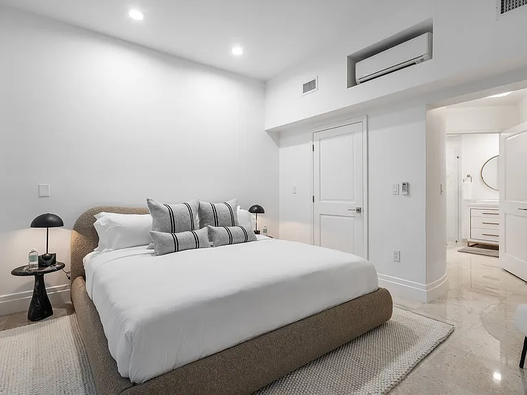 A serene escape featuring a plush king bed, soft linen, and marble flooring, complete with ample closet space and ambient lighting.
