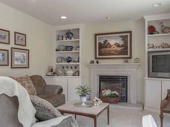 Built in shelving, electric fireplace, and storage in separate family room.