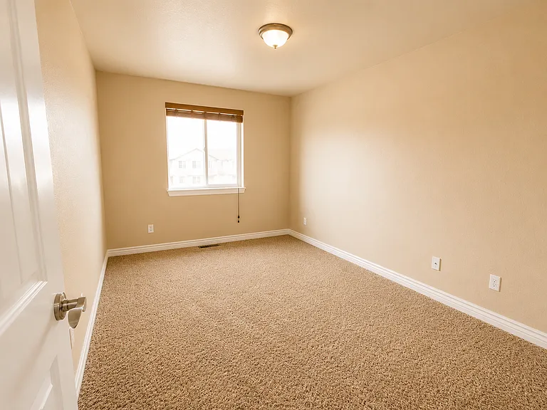 Second bedroom with natural light and carpet _ works well as a guest room, nursery, or home office.