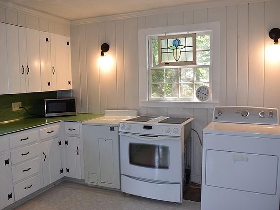 Kitchen with stove and frig, washer and dryer.
