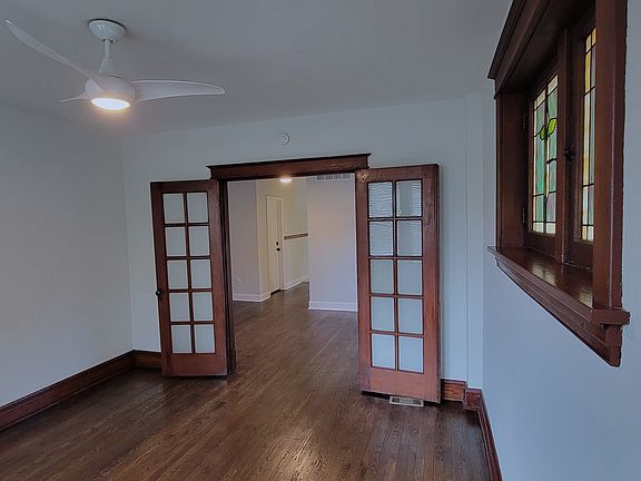 Primary Bedroom with French Doors, Stained Glass Windows, and reomte controlled fan.