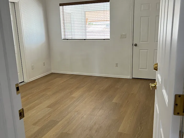 Bedroom with window and door to Arizona room