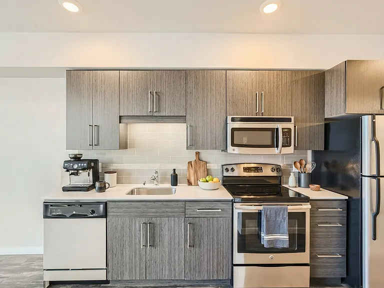 Bold dark cabinets meet bright stainless steel appliances.