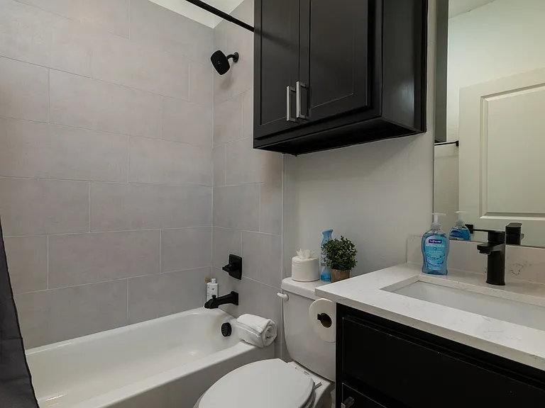 Second full bathroom - shower-tub combo, toilet and sink area.