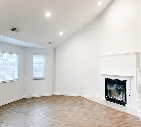 Living room with fireplace, vaulted ceiling, recessed lights
