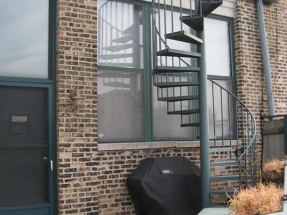 Entrance to unit with gated patio and spiral stairs up to personal rooftop deck
