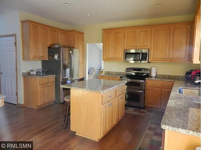 Chef worthy kitchen with center island, double oven and stainless appliances.