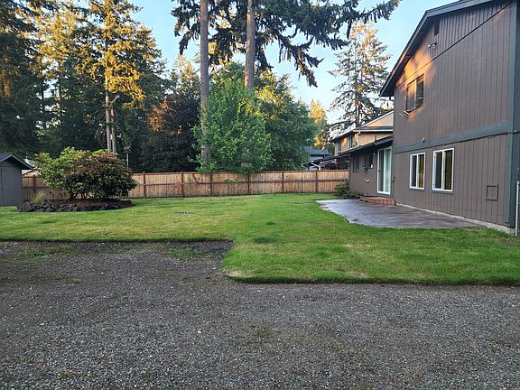 Backyard view from side yard, stamped concrete patio outside sliding glass door from kitchen.