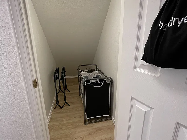 Closet under the stairs with access from the Primary Bedroom. Laundry sorting baskets and room for luggage.