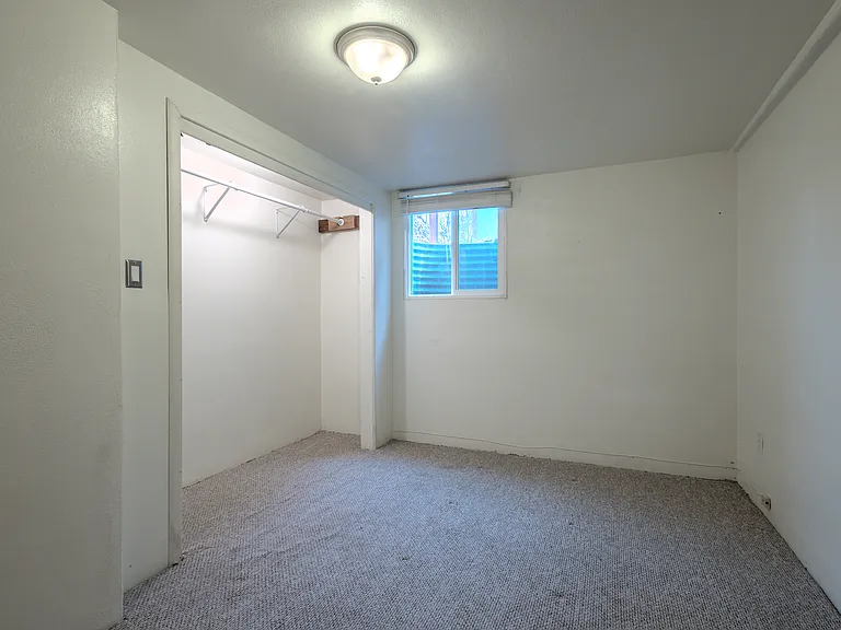 Garden level bedroom with large closets, large egress window and wood blind for privacy.