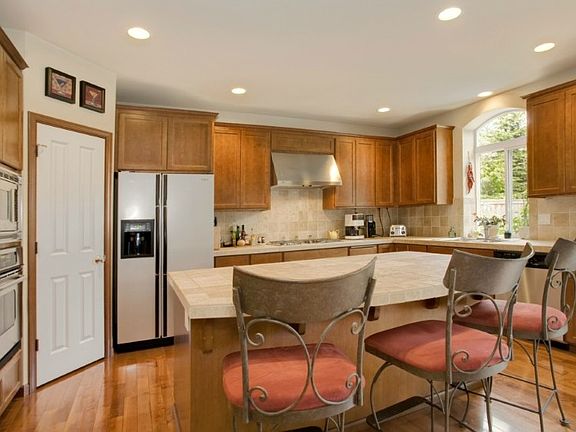 Chef's kitchen has SS appliances, walk-in pantry, gas range, extra large island/breakfast bar & dining area! Opens to living room. Beautiful birch hardwood floors in main entry, hall & kitchen.