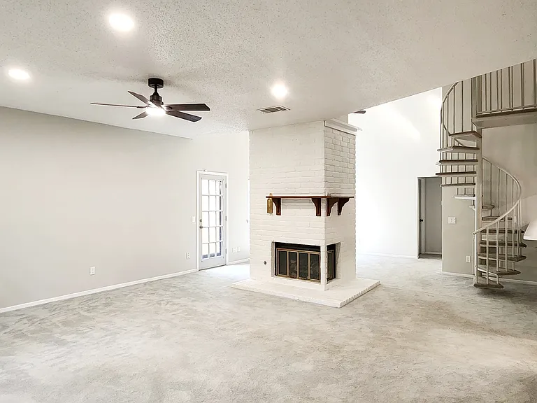 Living room with recessed lighting and a featured white and maple brown fireplace