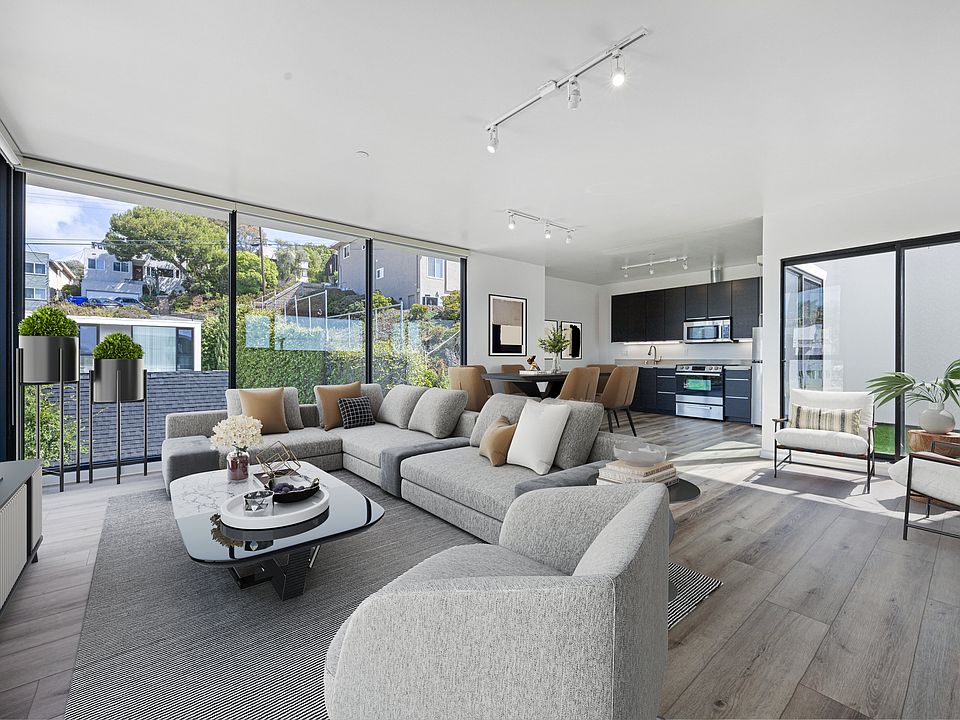 Bright open-concept living, dining, and kitchen space with new modern floor-to-ceiling blackout curtains for a sleek and comfortable finish.