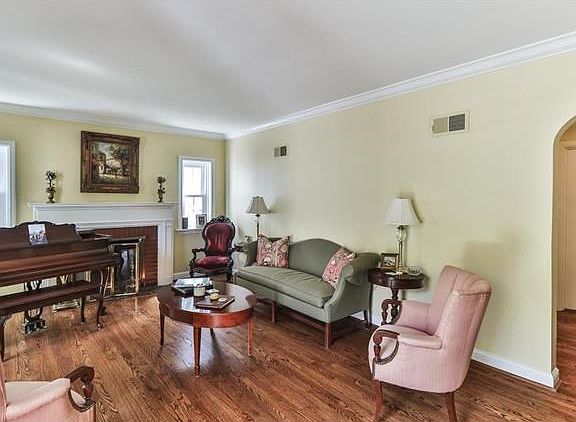 Formal living room with great natural light and charming arched doorways and crown molding