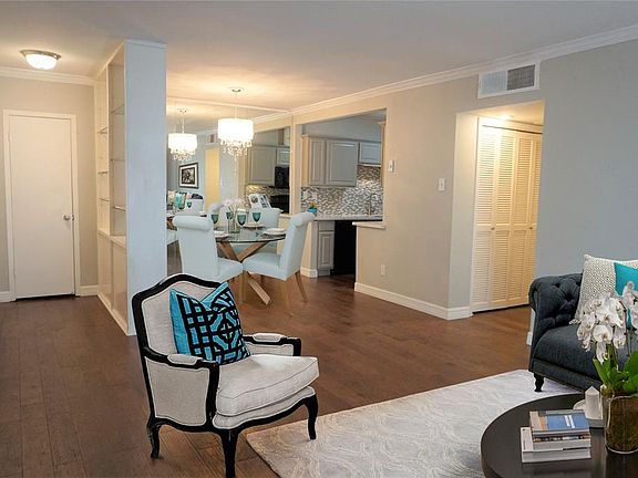 Living room is open to the dining space. Wood floors continue in all spaces except bathrooms.