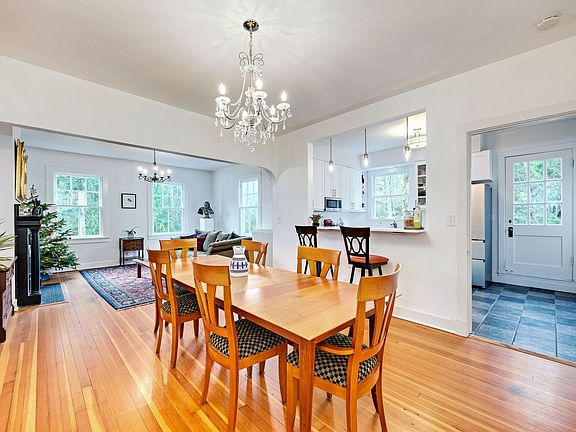 The dining space boasts a stunning chandelier and an adjoining breakfast bar, perfect for entertaining or enjoying morning coffee.