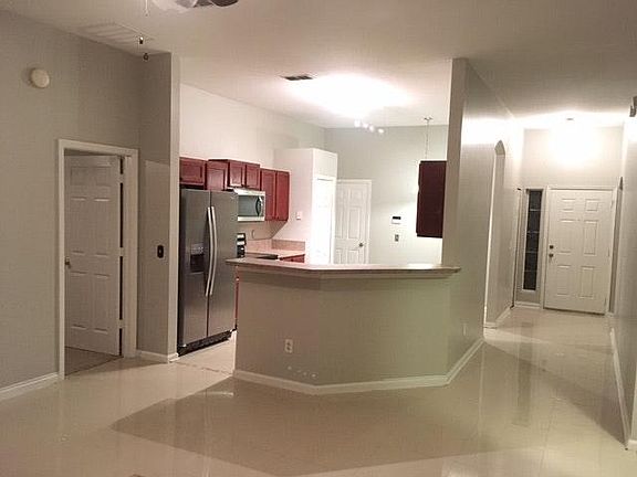 Looking into kitchen off living area. Left is master bedroom. The front door is on the right of the image.