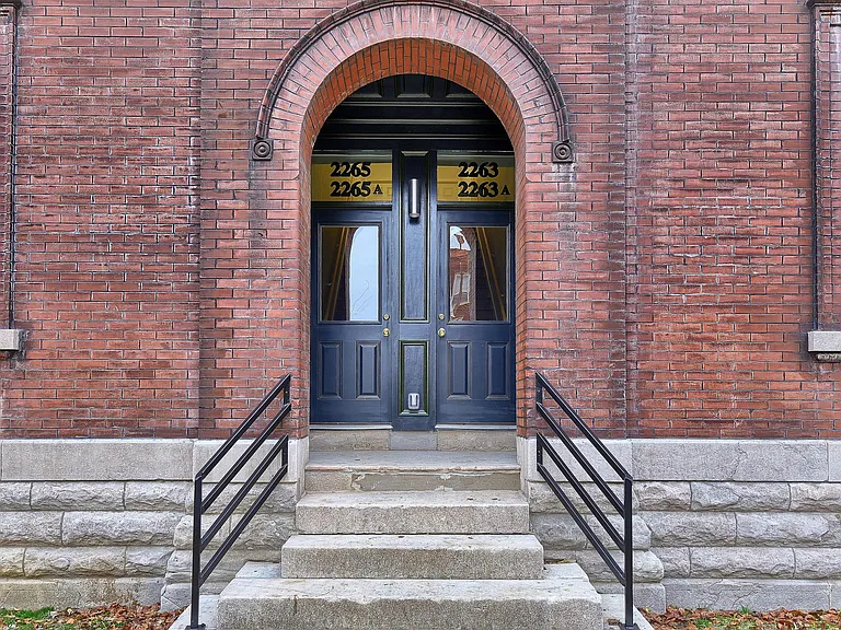 Original brick archway and classic double-door entrance showcase the building's historic architectural character.