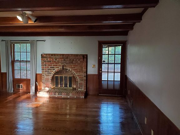 Living room with hardwood floors and wood burning fireplace.