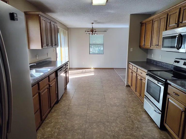 Spacious Kitchen viewed from laundry room. Lots of countertop for those who love to cook.