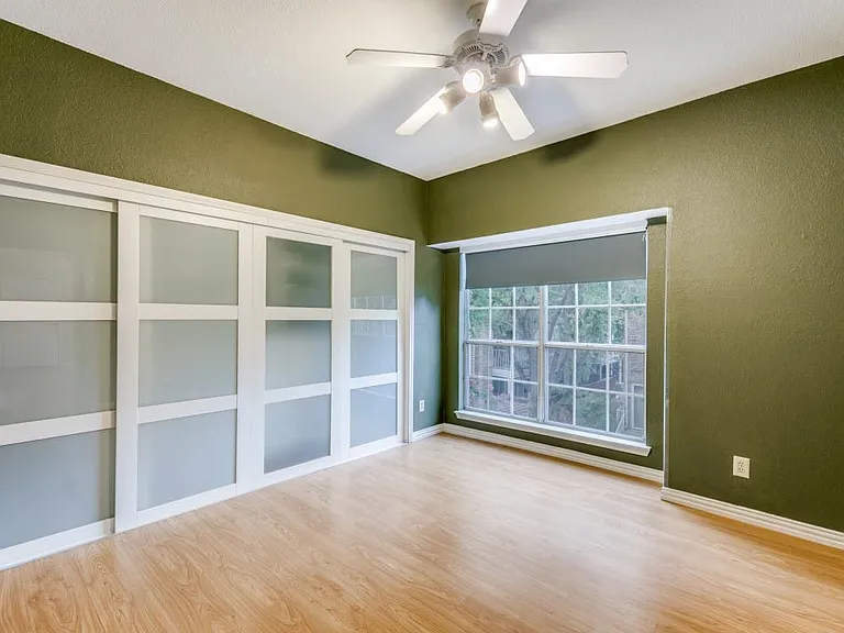 Master bedroom with custom closet system, natural light.