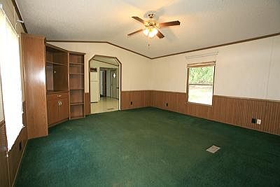 Large living room with ceiling fan and built-in bookcase/ent