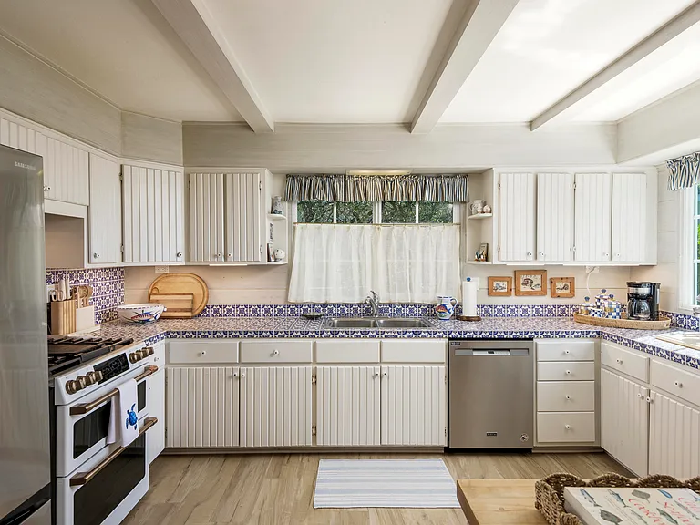 Large open kitchen with new refrigerator and new 6 burner gas range oven.