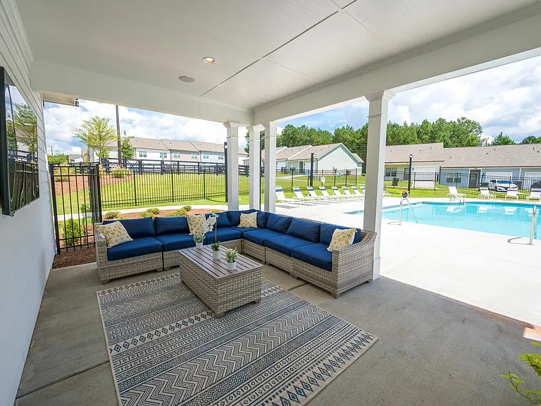 Covered patio on the pool deck with lounge seating.