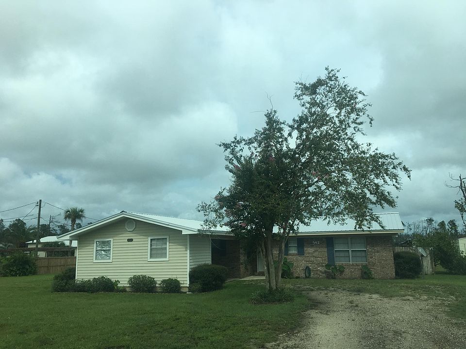 Front of house with drive through carport