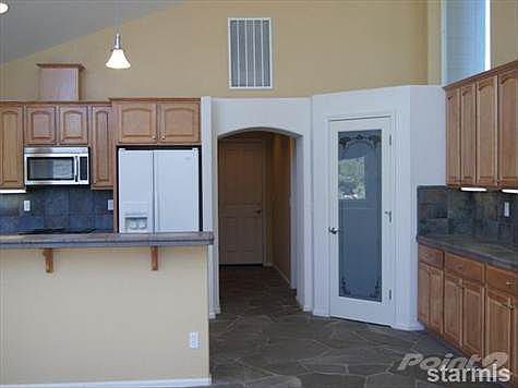 The kitchen with pantry and hallway towards additional room, laundry room and garage.