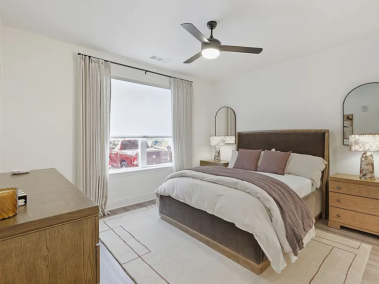 Spacious bedroom with a comfortable bed, stylish furniture, and plenty of natural light