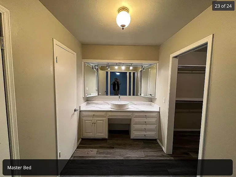 primary suite bathroom with separate vanity and large walk in closet and separate linen closet
