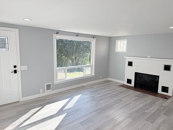 Living room with new fireplace, paint, flooring, and lighting