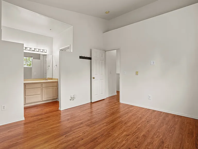Master bedroom showing dual sinks and entry door.