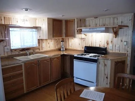 Kitchen: window over cast iron sink, propane stove, full size refrigerator - 5875 Highway 550