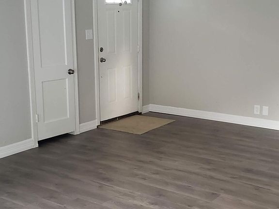 Living room with new flooring, looking toward the front door and coat closet