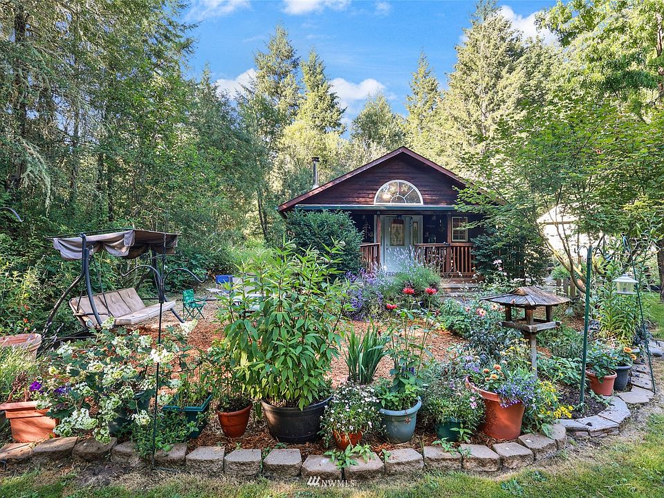 Enchanting gardens lead to charming home.>