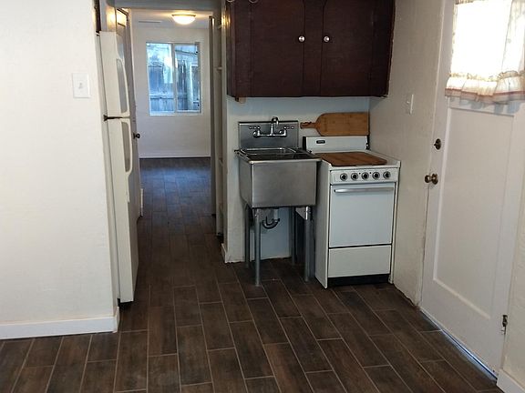 Tiny Kitchen. Electric stove, sink and full size refrigerator. Picture taken from Livingroom looking passed kitchen to bedroom.